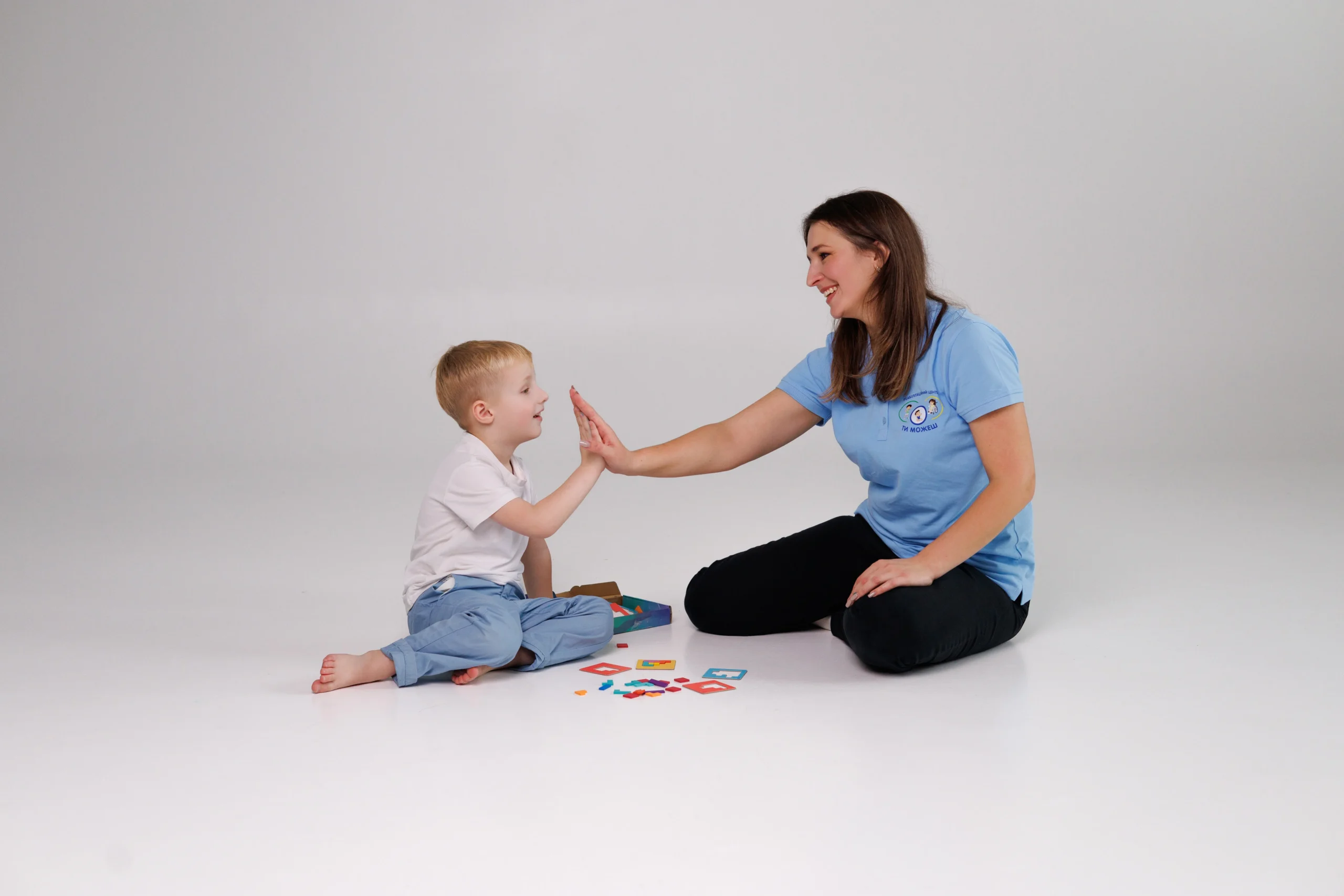 Психологиня з хлопчиком пацієнтом на занятті